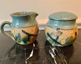 Nine piece set of hand glazed ceramic pottery including: $40 - creamer, and sugar; $40 - four small mugs; and $30 - two larger mugs; 4 1/2 in. H large mugs; 3 1/2 in. H small mugs