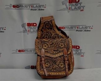21	

Tooled leather saddle bag.
Tooled leather saddle bag. This saddle bag features floral tooled leather and comes equipped with front D rings. Double roller buckles for security. Bag measures 10" x 10" x 3" with a 4" gusset. 