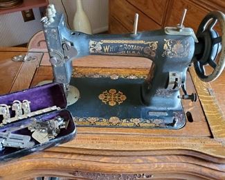 Antique White treadle sewing machine in ornate cabinet with additional feet