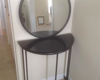 Black metal entry table and mirror.  Measures 30.5" tall x 27" wide x 13" d.  Mirror is 24" round.  Set is $75