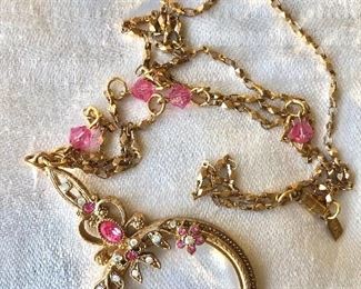 $30  "1928" signed Magnifying glass pink rhinestone  and gold accents on chain 26" long , magnifying glass 2.5" Long 