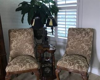 Set of two upholstered chairs.   There are two tables and behind is plant stand.