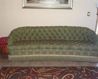 1930'S UPHOLSTERED TUFTED 8 FOOT SOFA WITH FRINGE.