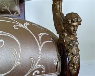 Close up of the winged gilt bronze mounts on the antique settee.