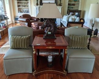 Egyptian Revival inlaid mahogany table with greek key detail and brass mounts, flanked by a pair of freshly upholstered celadon slipper chairs and vintage bronze horse head table lamp.