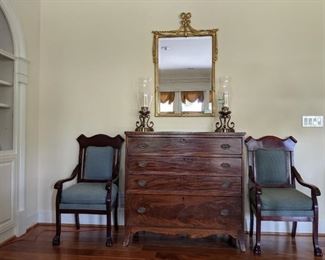 Antique American 5-drawer chest, from Baltimore, MD, flanked by a pair of freshly upholstered mahogany armchairs, pair of 3-light hurricane lamps and gilt wood beveled wall mirror, by Decorative Crafts. 