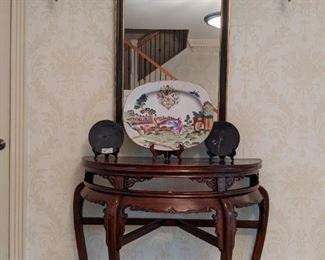 Antique, hand-carved wooden Asian demilune entry table (with inlaid leaf, next pic) black/gold wooden wall mirror in a trumeau stye, 20" long hand-painted Asian porcelain platter, flanked by a pair of hand-signed glazed black luster opalescent plates. 