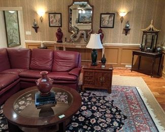 Another view of the Roche-Bobois leather sectional, Asian 3-drawer/2-door wooden chest, antique oak library table, Asian hand-painted/lacquered octagonal display case, mahogany coffee table with beveled glass top, hand-woven Persian design rug (9 x 12), pair of 16"tall oxblood glazed ginger jars, hand-chased silverplated dragon, from Bali and large wall mirror, with beveled glass.