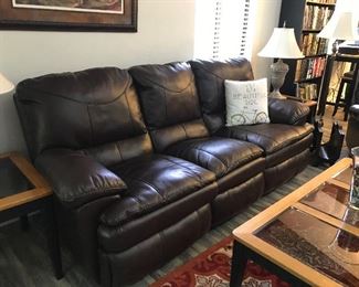 Dark brown faux leather manual reclining sofa. Small scuff on each of the two back upper corners, but otherwise in excellent condition.