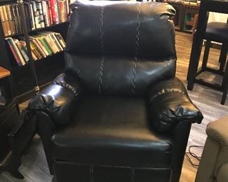 Black faux leather electric recliner with white stitching. 
