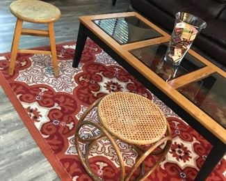 Area rug, step stool and rattan foot stool.