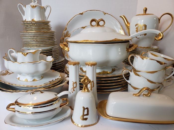 Vintage Hutschenreuther 81 pc china set in Selb pattern. Dishes are a gorgeous white with gilded gold trim. Set includes tea cups, saucers, platters, plates, soup terrain, tea pot, dessert plates, bowls, salt and pepper set, bell and sugar and creamer set. https://ctbids.com/#!/individualEstateSales/316/9887