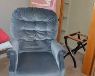 blue easy chair and luggage rack