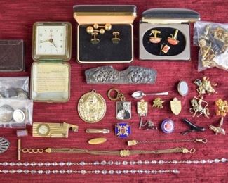 107	Grouping of Accessories and Coins	Vintage commemorative key chain "1855-1955" marked Arthus Bertrand; gold tone vintage lighter with clock marked "Swank Swiss Made" (does not work) also inscribed "Japan" on lighter; Carolyn Roehme cufflinks; various gold tone cufflinks; Alva Studios single frog cufflink; tie clips; vintage Endura Starlet travel clock in case (not working); gold tone watch chains; rhinestone belt buckle with TK inscription; Lois Hill leather box; silver tone comb cover; four sets gold tone cufflinks; two single gold tone cufflinks; set of gold tone cufflinks with orange faux stones with matching tie tack; one single copper cufflink; pendants; pins; Show World tokens; 1904 Barber dime; Kendall oil and misc. tokens and international currency (two pence; Kuwait; euro cent; drachma); rosary beads
