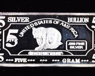 346	Group of Gold and Silver Bars	A group of silver and one gold micro bars, including: 1 gram of gold 1 gram of sterling silver with horse design. 5 grams of sterling silver with bear design. 5 grams of sterling silver with moose design. Very good condition for all pieces.
