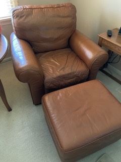 Two leather chairs with ottomans