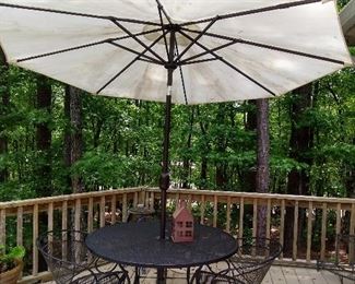 Wrought Iron table with 4 barrel back chairs.  Adjustable tilt  umbrella  with stand.