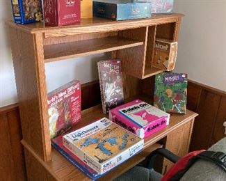 Assorted games displayed on wooden desk with chair