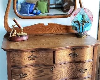 Vintage curved front four drawer dresser has cheval mirror