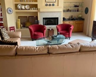 Backside of a leather sectional, two vintage red velvet club chairs, silver, bar war, and lots of great stuff.