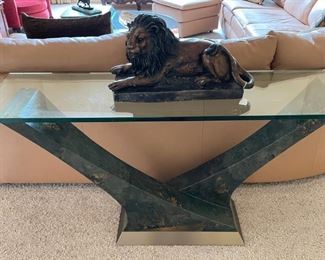 One of several art glass console tables. The glass is an inch thick. Leo the bronze lion is happy on his perch.
