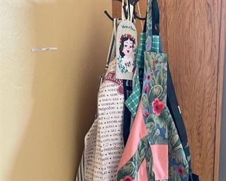 Lots of fun aprons and a wrought iron coat rack.