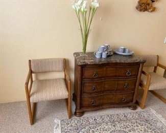 Detail of small bureau with marble top as well as two of five mid-century modern open arm chairs.