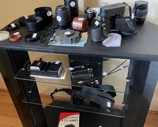 Camera lenses and a zen angled stereo system tower.