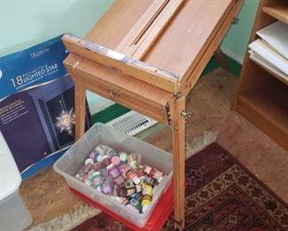 A whole room full of craft items. Stained glass, paints, Easels, material, papers and more.