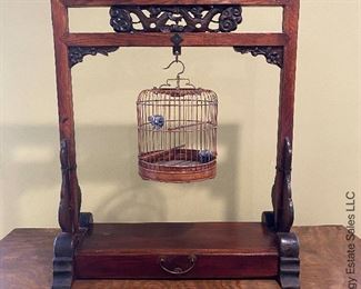 ITEM 4: Antique Chinese birdcage on stand. Stand has intricate carvings, and a drawer. Delicate bird cage has Chinese ceramic vessels for water and food. 24.75” x 29.25” tall x 10.5” wide $325