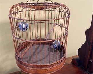 ITEM 4: Antique Chinese birdcage on stand. Stand has intricate carvings, and a drawer. Delicate bird cage has Chinese ceramic vessels for water and food. 24.75” x 29.25” tall x 10.5” wide $325