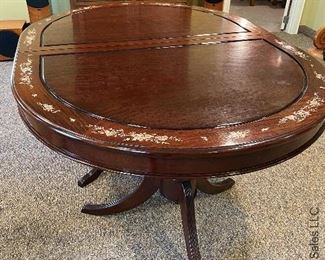 ITEM 7: Mother of pearl inlay table, oval, measurement is smallest size. comes with two arm chairs and six side chairs. Chairs have solid wood seats, come with brocade custom seat cushions and feature mother of pearl inlay on both sides of center back. Two leaves 17.825” wide, as shown - 59” 3/8 x 30” tall, 44” $1,350