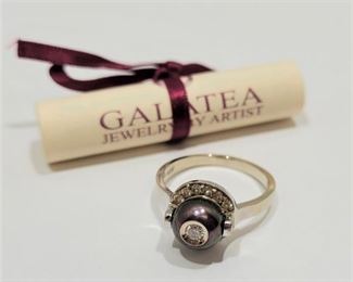 Galatea 'Diamond In A Pearl' Diamond Ring Made by Galatea Jewelry by Artist. Chi Galatea Huynh. From the "Diamond In A Pearl" collection. 14k white gold with Tahitian black pearl encasing a diamond in center, surrounded by more diamonds. Stamped 'GALA 14K'. Pearl Size: 8.5mm Diamond: 0.26cttw Ring size: 7.5 Retails at $2,190.00 This same ring type by Galatea can be found on their website here: https://shopinde.com/product/2058?v=5317&r=1