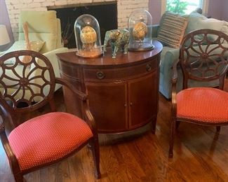 Matching pair of web-backed arm chairs and half-moon cabinet with drawer