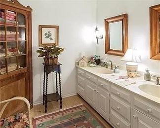 beautiful rug, chair and corner cabinet used for linens