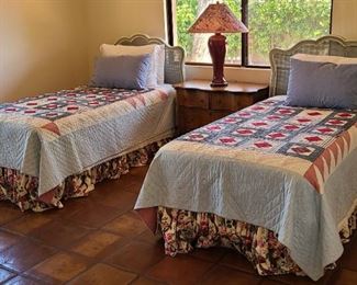 Twin beds with quilts with hand-stitching.