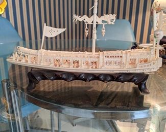 Chinese  Circa 1900, carved Junk Boat .  With Great detail This was given to the owner while when she lived in Hong Kong.  Wooden Stand the ship of the body is 10" long .  The detail in the boat , where there are people and the doors slide.  The dragon is on the top of the boat. 