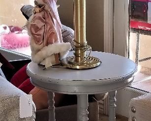 Round silver gray candlestick table and mid=century modern lamp.