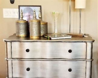 Modern silver dresser and mid-century modern lamp.