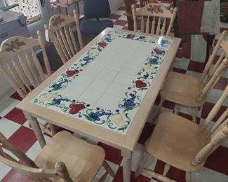 Sturdy well made oak dining table and 6 chairs w fruit motif and inlaid art tile.  The corner tile is signed by the artist.  