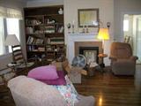 LOTS OF CHAIRS AND BOOKCASE FULL OF BOOKS.