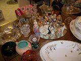 Table full of Hummels, Cybis, Royal Doulton, Coors Pottery piece, Lalique, Waterford, and misc china and glass
