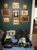 Table of cameras and equipment plus some nice wall decor