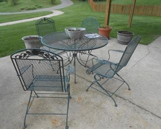 Metal patio set with (4) chairs and various planters in the background