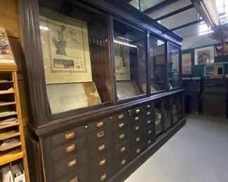 An antique Mercantile Apothecary Pharmacy Shop cabinet wall unit  that was originally used in an apothecary store in Cambridge, Massachusetts. They were later used at Karwacki Pharmacy in Baltimore.   Another section is in this sale, Part I while two other sections will be in the Part II sale. ...To Register and To Bid go to https://capitolsalesservices.hibid.com... 