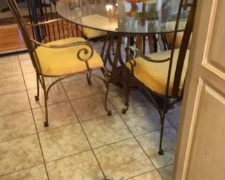 Heavy wrought iron table with glass top & 4 chairs