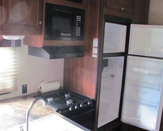 Kitchen area with Micro wave Propane stove double sink and refrigerator.