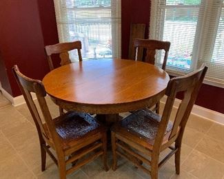 #40 Antique oak table on casters, 4 chairs with embossed leather seats and 2 leaves. 42"-58"x42"x30" SOLD