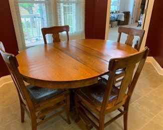 #40 Antique oak table on casters, 4 chairs with embossed leather seats and 2 leaves. 42"-58"x42"x30" SOLD