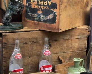 Old wooden bowl with rolling pins . 
Double cola bottles 